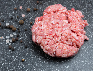 Minced meat on a marble board and spices