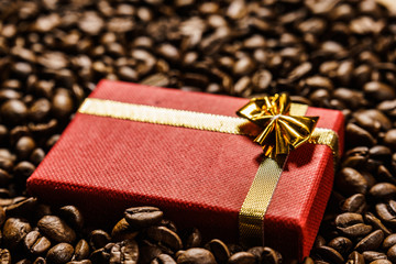 Red gift box on roasted coffee beans.