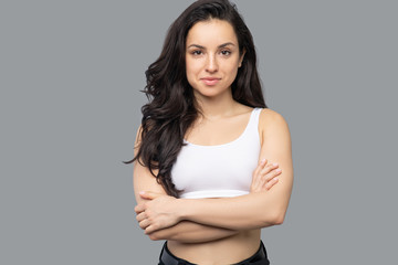 Pretty brunette girl standing with her arms crossed