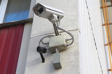 Surveillance camera mounted on wall of house