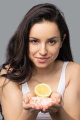 Beautiful dark-haired girl holding an orange in her hands
