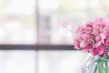 Beautiful fresh pink flowers bouquet decoration with natural light from window blurred background and copy space for text.