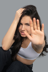 Beautiful dark-haired girl in a white top looking stressed