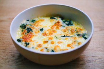 Baked Spinach with Cheese on wooden texture. food concept.