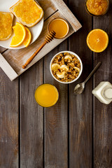 Vegetarian breakfast with granola and fruits on wooden background top-down frame copy space