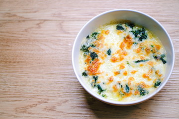 Baked Spinach with Cheese on wooden texture. food concept.
