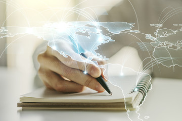 Double exposure of abstract digital world map with connections and man hand writing in notepad on background, big data and blockchain concept