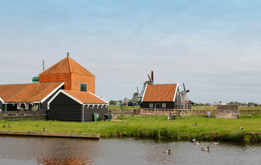 Fototapeta na wymiar View of traditional Dutch farm houses along a canal in spring at the Zaanse Schans, Zaandam, Netherlands