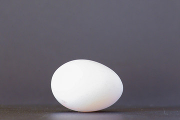 Close up of an egg laying on the table over black background