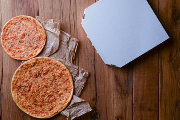 Two pizzas on the dark rustic wooden table. Flat lay, top view. Copy space web design banner.