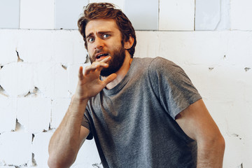Portrait of Expressive young  bearded man scared and nervous