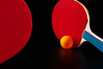 Red ping pong racket on dark background. Sports equipment