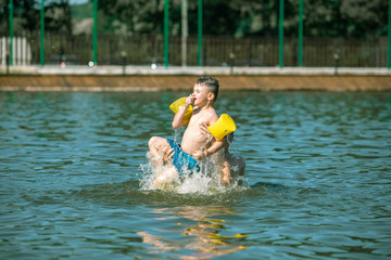 father throwing son in water having fun