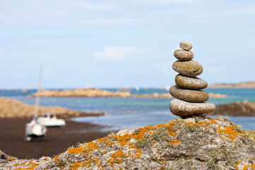 Empilement de pierres rondes sur une plage en Bretagne, France. - obrazy, fototapety, plakaty