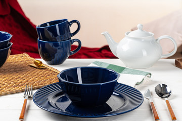 Classic blue ceramic tableware on checkered tablecloth close up