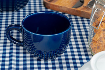 Classic blue empty ceramic tea cup on kitchen table close up