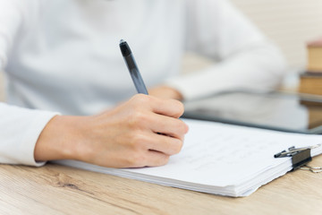 Close up of a young cheerful Asian student female university student studying in self study room in the university library to do her assignment and prepare for examination.