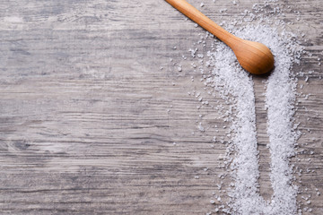 Wooden spoon witj salt on a light rustic wooden table. Web design banner with copy space for text