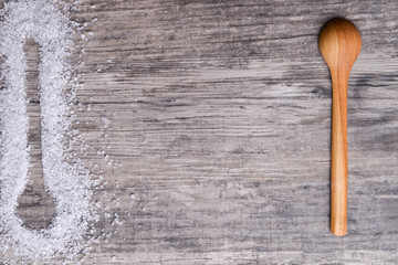 Wooden spoon witj salt on a light rustic wooden table. Web design banner with copy space for text