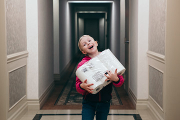 Happy Caucasian girl holding pack rolls of toilet paper. COVID-19 coronavirus panic shopping hoard...