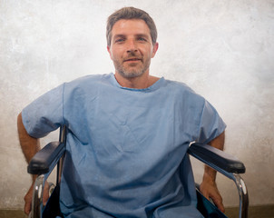 young attractive happy and positive hospital patient man in wheelchair smiling hopeful recovering of virus infection or health problem healing the pain feeling cured