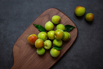 Freshly green plum on dark gray background.