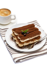 Classic tiramisu dessert on ceramic plate and cup of coffee isolated on white background with clipping path