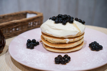 Bubble milk tea pancake. A stacks of Japanese fluffy pancake topped with milk tea fresh cream and bubble/boba pearl at cafe.