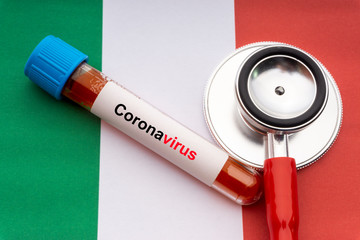CORONAVIRUS text, stethoscope and blood sample vacuum tube on Italy flags background. Covid-19 or...