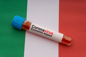 CORONAVIRUS ECONOMIC IMPACT text and blood sample vacuum tube on Italy flags background. Covid-19...