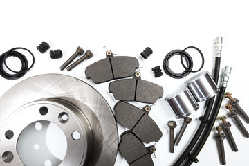 brake parts on white: brake pads, disc, brake hose, guides, cylinders .