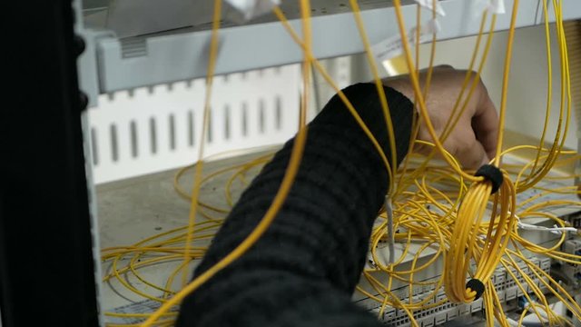 Network engineer in server room works with optical patchcord and optical module.