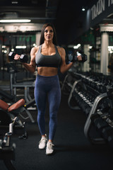Plakat Fitness woman on training. Young woman in the gym. 