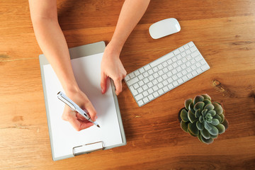 Female hands working on wooden work place with modern gadgets  top view