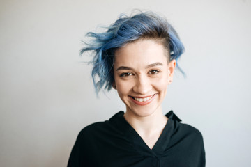 Fototapeta premium A beautiful girl with blue hair is smiling.