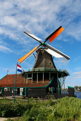 Fototapeta na wymiar View of traditional Dutch windmills along the canal in spring at the Zaanse Schans, Zaandam, Netherlands