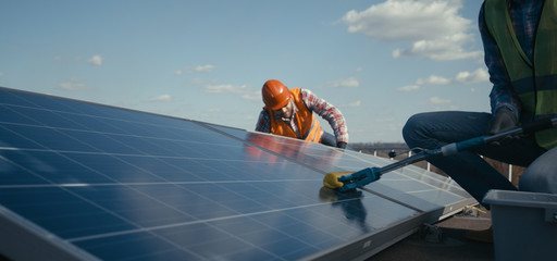 Technicians cleaning and maintaining solar panels