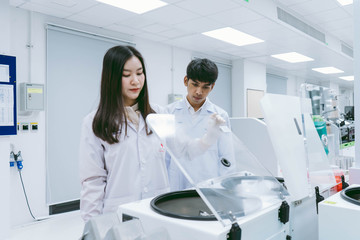 Fototapeta premium young female scientists open centrifuge in medical laboratory 