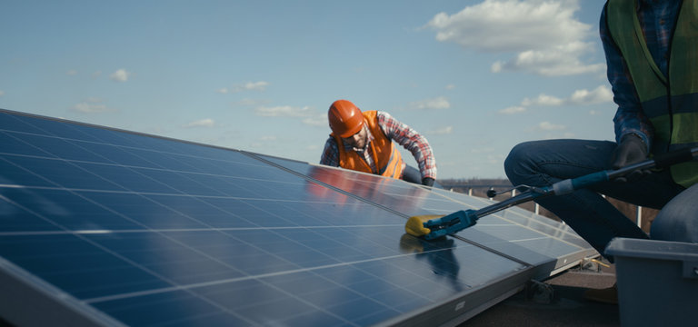 Technicians cleaning and maintaining solar panels