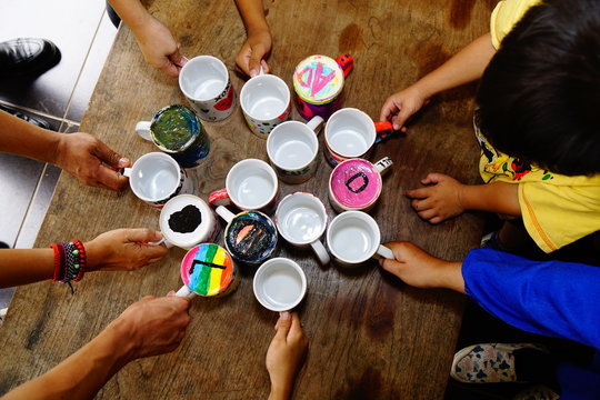 Hand painted mugs are displayed on the table created by girls and boys of an orphanage in a social program. 