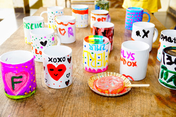 Hand painted mugs are displayed on the table created by girls and boys of an orphanage in a social program. 