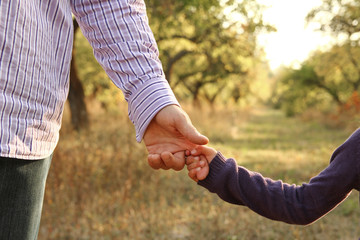 the parent holding the child's hand with a happy background