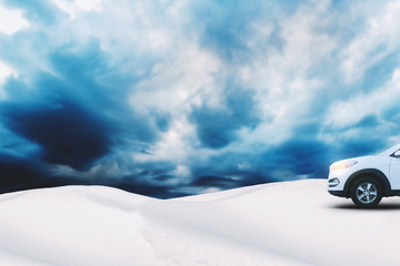 Fototapeta na wymiar Crossover SUV Car on Winter Landscape with Snow Dunes and Cloudy Sky on Background