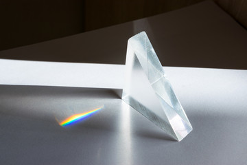 Sunlight passes through a prism, causing the light to refract and spread, creating a spectrum of...