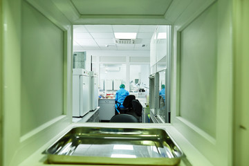 back shot of medical scientist in protective suit and medical disposable hat working at laboratory