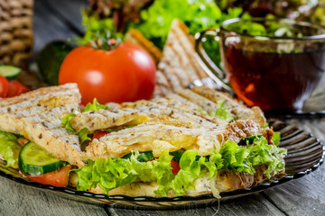 Panini sandwich with ham, tomato and lettuce.
