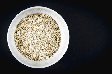 Oatmeal recipe with walnuts, prunes, cinnamon and sugar. Oatmeal in a white cup with copy and paste space