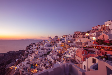 Fototapeta premium Church of Santorini island, Greece. Incredibly romantic sunset on Santorini. Oia village in the morning light. Amazing sunset view with white houses. Island of lovers. Postcard