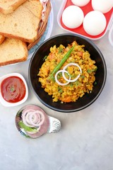 Indian Breakfast Dish - Parsi Akuri or Anda Bhurji or Indian spicy scrambled eggs served with toasted brown bread & ketchup. Famous Indian street food. Ingredients background with copy space.