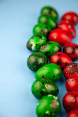 Easter eggs background. Green and red eggs. Colorful Quail colored eggs. Place for text. Different little painted egg set. Dietary nutrition. 